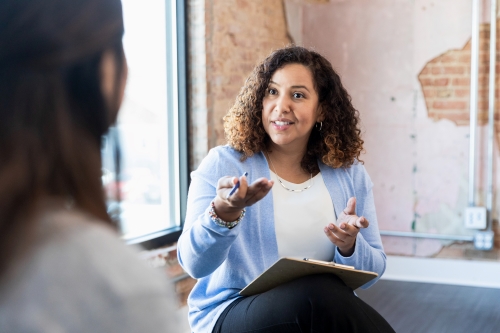 Woman speaking with clipboard on her lap