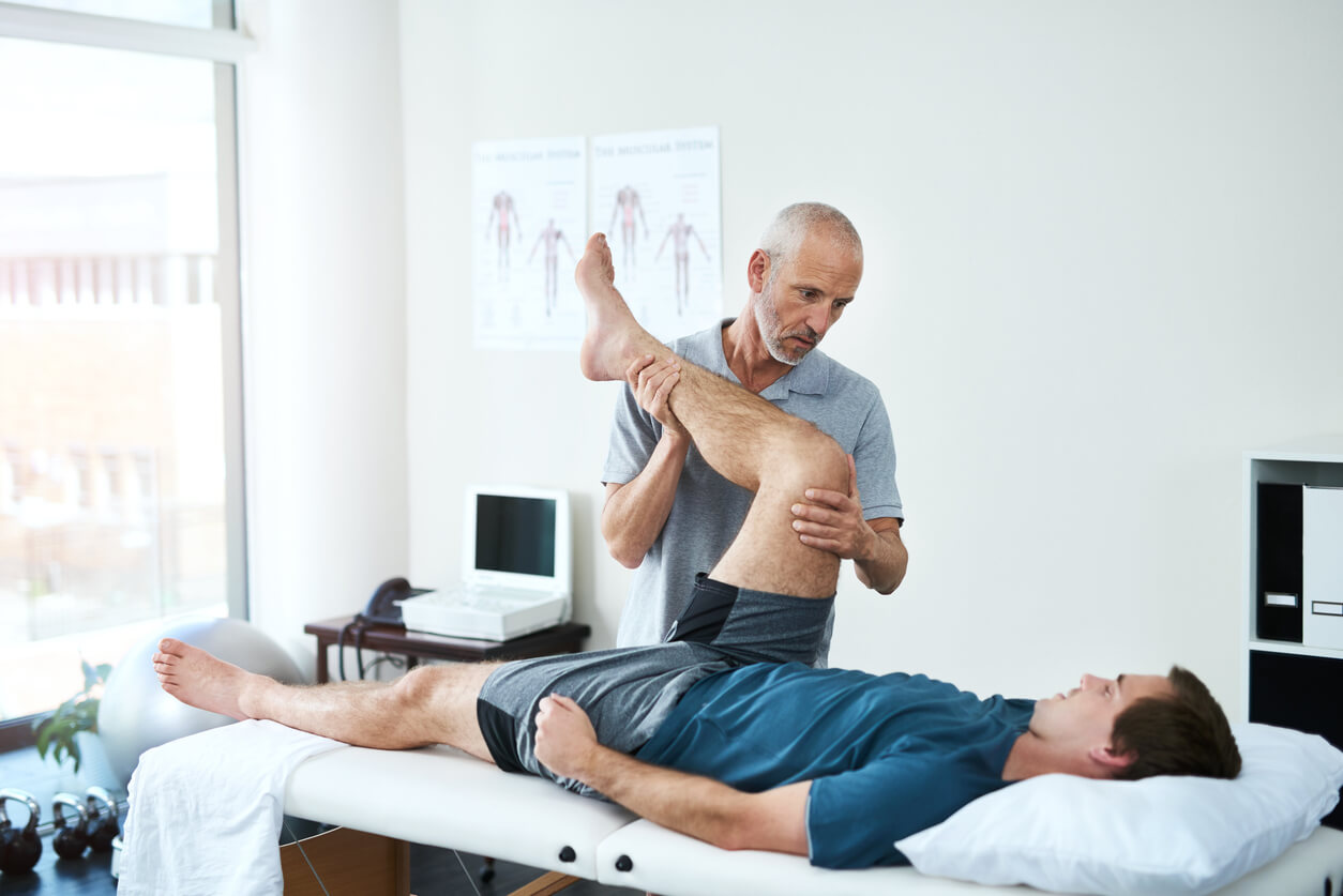 Physiotherapist manipulating patient legs